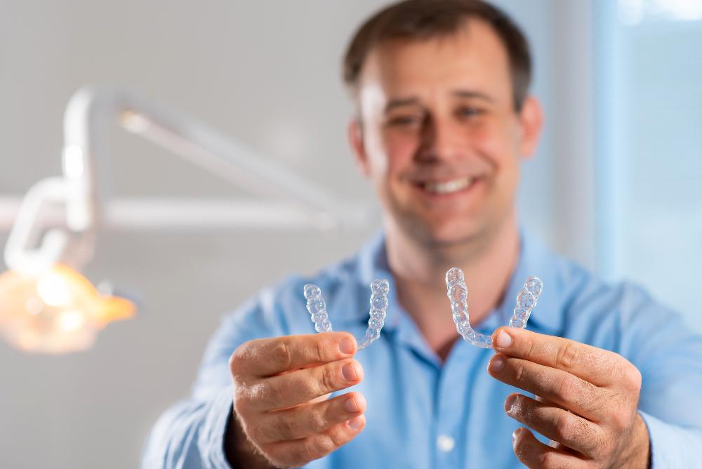 man holding two clear plastic aligners | invisalign parramatta