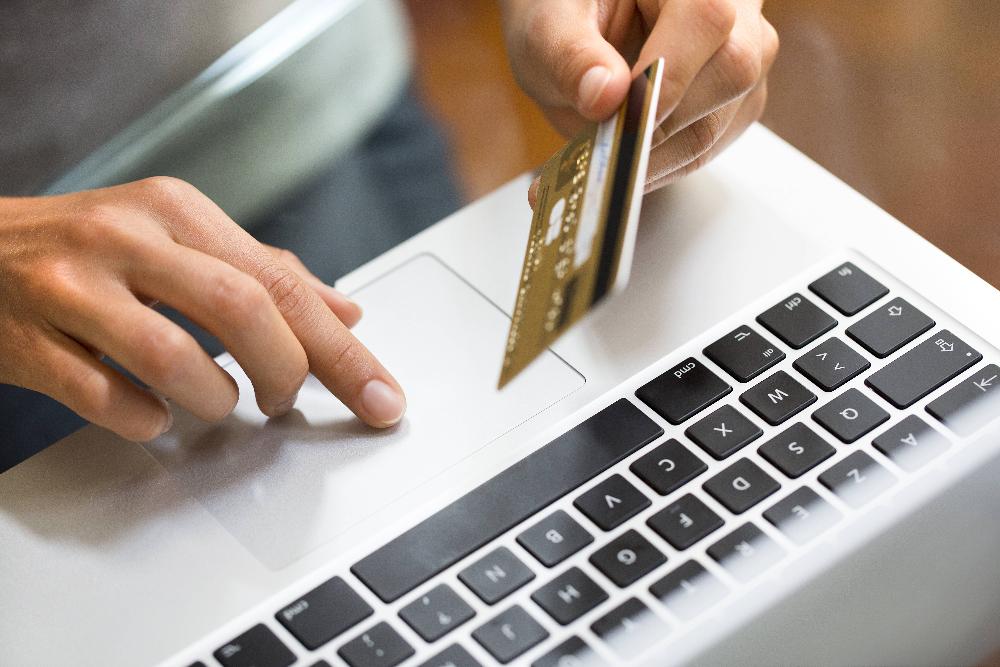 person holding credit card with laptop | dental clinic parramatta
