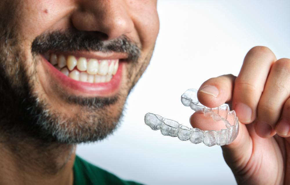 patient holding clear plastic aligner | invisalign parramatta