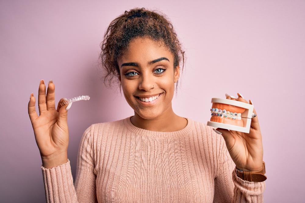 woman with curly hair holding clear plastic aligner | invisalign parramatta