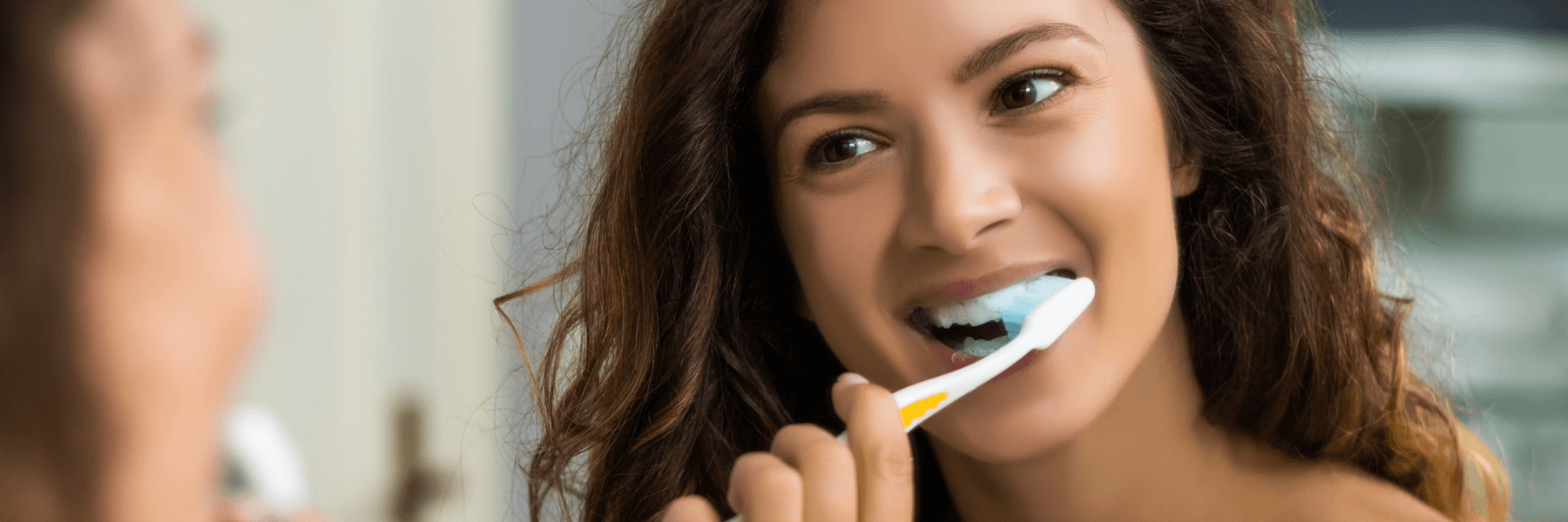 Woman brushing her teeth with a manual toothbrush in Parramatta