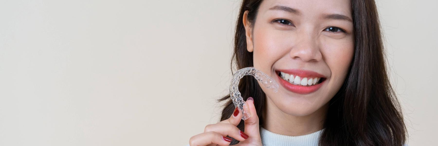 invisalign parramatta | woman holding aligner