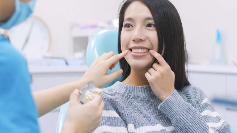 A woman standing confidently after a dental appointment in parramatta