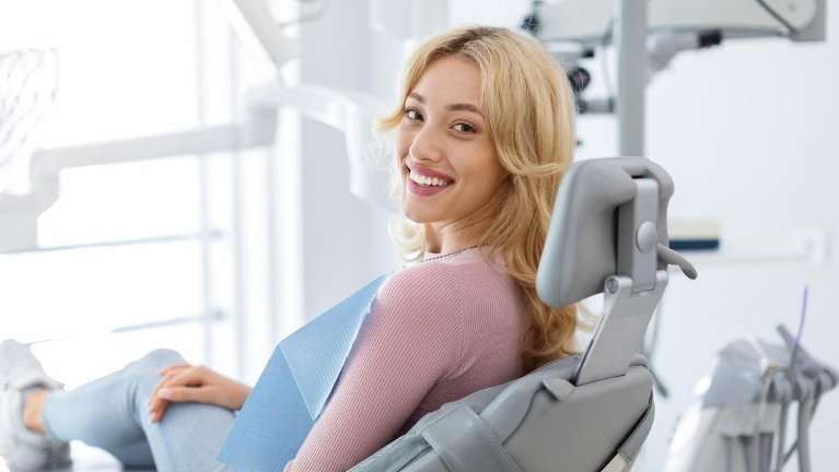 blonde woman sitting in dentist exam chair | dentist parramatta