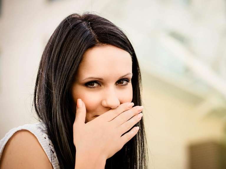 woman putting hand over mouth | dental clinic parramatta