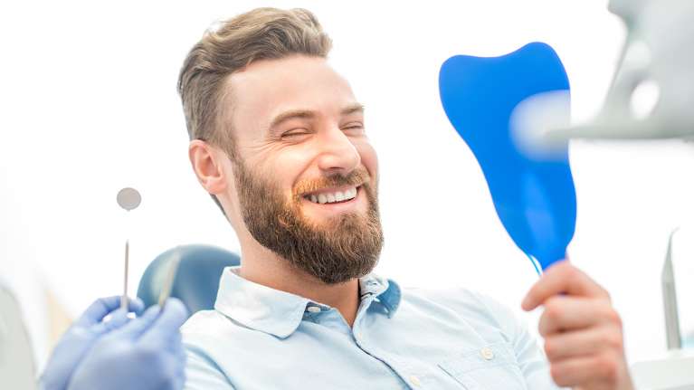 man looking at new veneers in parramatta